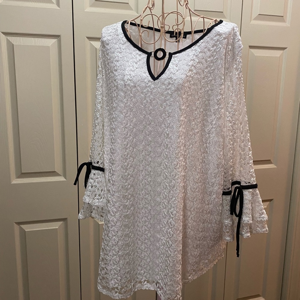 White lace blouse with black accent.